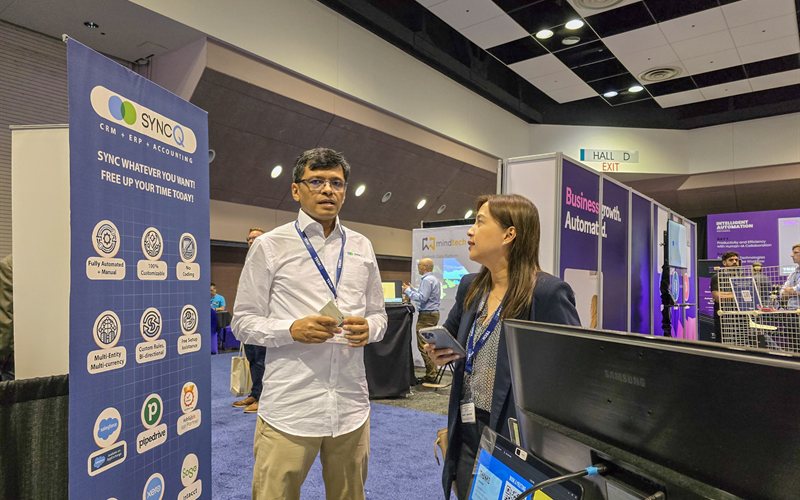 SyncQ booth with banner and visitor